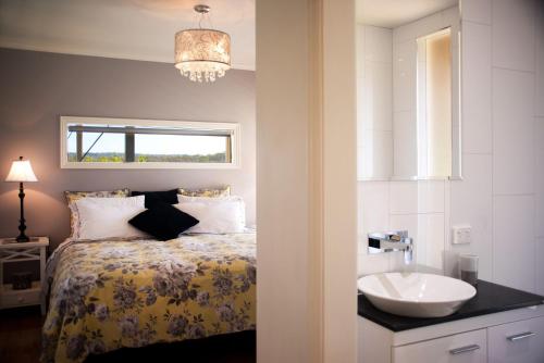 a bedroom with a bed with a sink and a window at Aroona in Daylesford