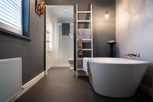 a bathroom with a white tub and a toilet at Aysgarth in Daylesford