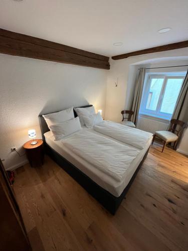 a bedroom with a bed with white sheets and a window at Altstadtjuwel in Gmunden am Traunsee in Gmunden