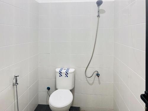 a bathroom with a toilet and a shower at RedDoorz Syariah @ Binjai Timur in Binjai