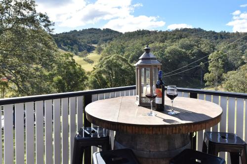 a table with wine glasses and a lamp on a balcony at The Glass Ceiling 360 degree Mount View Hideaway in Mount View