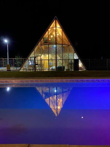 un gran edificio de cristal con un reflejo en una piscina en Cabaña Cumbre Algarrobo, en Algarrobo
