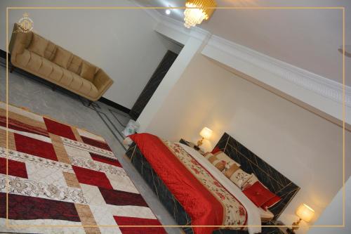 a bedroom with a bed with a red quilt at Khyber Guest House Swat in Saidu
