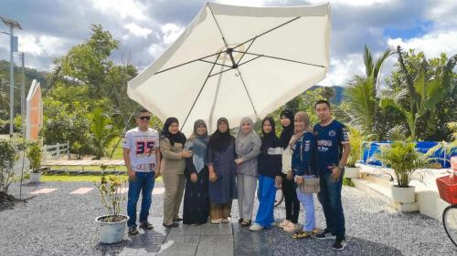 a group of people standing under a white umbrella at Cana Garden House 1 โฮมสเตย์ in Ban Khok