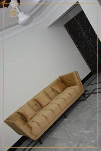 a brown couch sitting in a room at Khyber Guest House Swat in Saidu