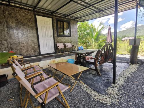 patio z krzesłami, stołem i stołem w obiekcie Cana​ Garden​ House​ โฮมสเตย์​ w mieście Ban Khok