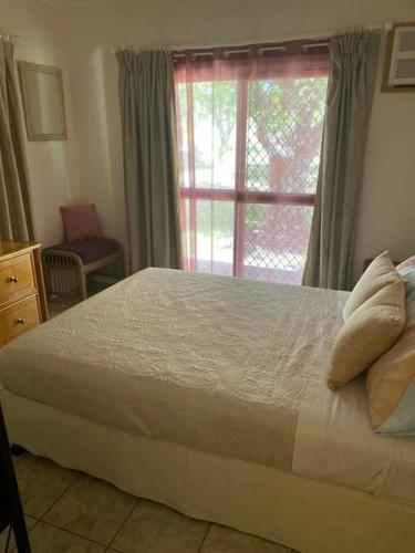 Un dormitorio con una cama grande y una ventana en Tamarind Gardens Camping, Caravans, Accommodation en Almaden