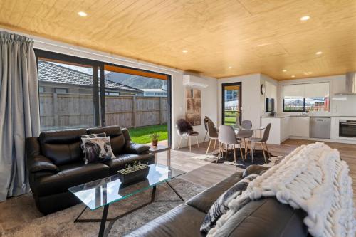 sala de estar con sofá y mesa en Custom designed holiday home, next to Cycleway., en Te Aroha