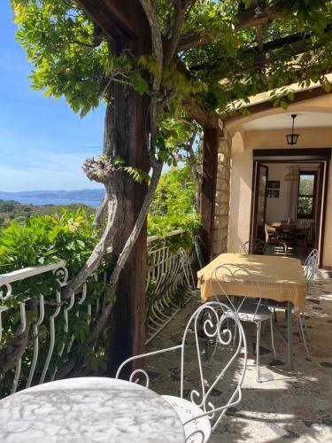 a table and chairs on a balcony with a tree at Villa Lilause in Hyères