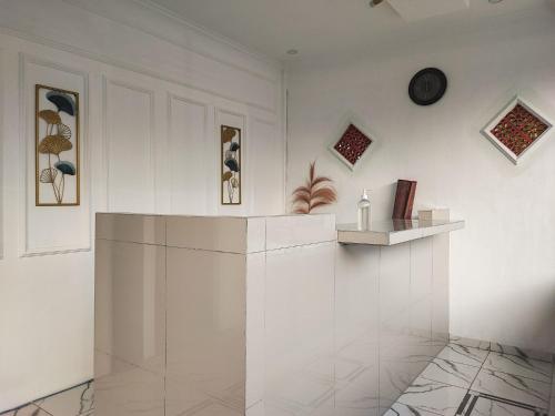a white room with a counter and a shelf at RedDoorz Syariah at Naffa Homestay in Sarolangun