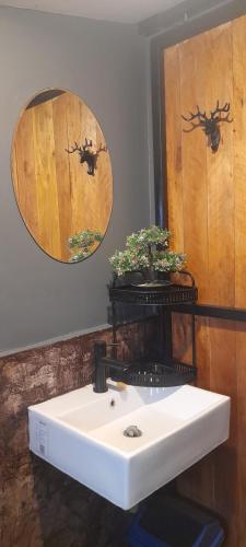 La salle de bains est pourvue d'un lavabo blanc et d'un miroir. dans l'établissement บ้านลูกจัน Bann Lookjan Trat, à Trat