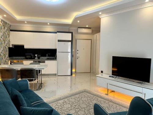 sala de estar con sofá azul y cocina en Premium Mediterranean Apartment, en Alanya