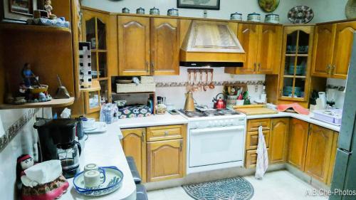 a kitchen with wooden cabinets and a stove top oven at Casona Rosa B&B, Morelia in Morelia
