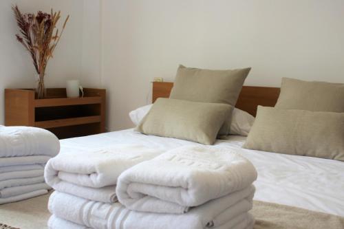 um quarto com uma cama com toalhas brancas em Vega del Tajo- CON PARKING GRATIS em Toledo