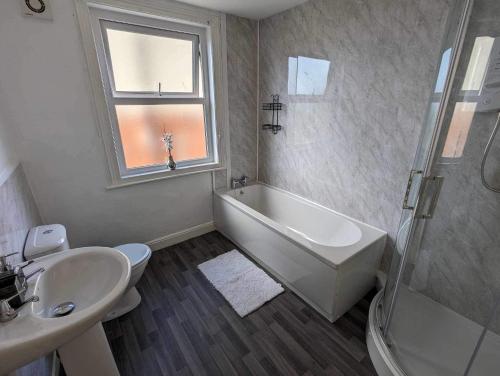 a bathroom with a sink and a tub and a toilet at Victoria House in Scarborough