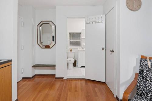 a white bathroom with a toilet and a mirror at Great Studio Location in Times Square Near Subway in New York