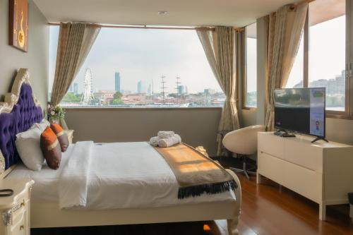 曼谷的住宿－Anandpura Riverside Hotel，一间卧室配有一张床、一张书桌和一个窗户。