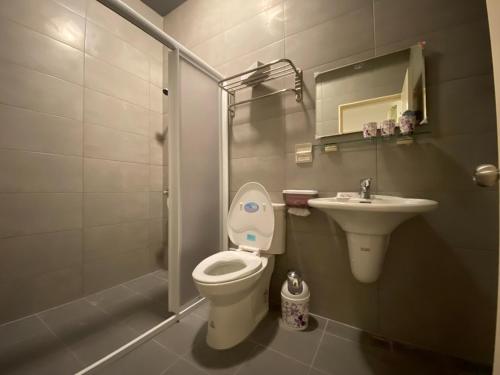 a bathroom with a toilet and a sink and a shower at 晨光夜色 in Magong