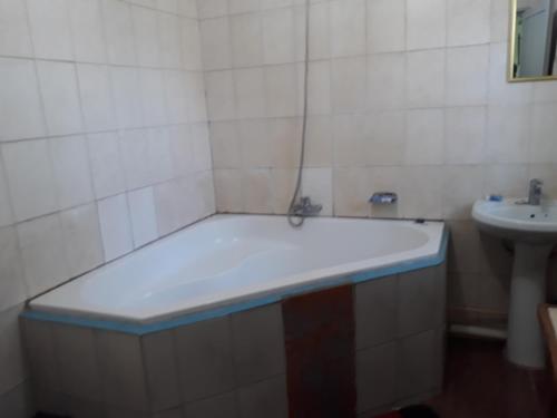a bathroom with a tub and a sink at Gloria's Bed and Breakfast in Livingstone