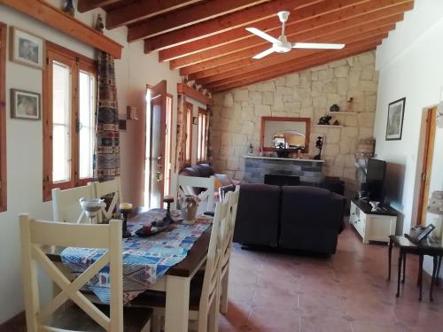 Despina country retreat في بافوس: غرفة معيشة مع طاولة طعام وجدار حجري
