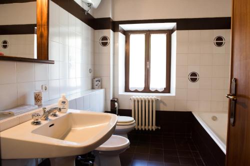a bathroom with a sink and a toilet and a window at Casale Fornello in Acquapendente