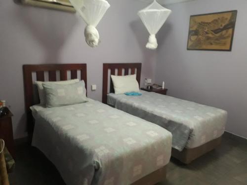 two beds in a room with two beds sidx sidx sidx at Gloria's Bed and Breakfast in Livingstone