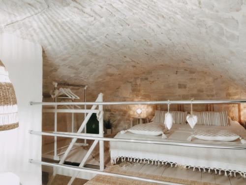 - une chambre avec un lit dans un mur en pierre dans l'établissement Casa De Amicis 24, à Sammichele di Bari