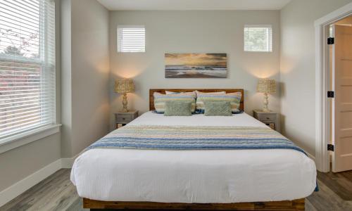 une chambre avec un grand lit et deux lampes dans l'établissement Queen Tide Cottage, à Ocean Shores