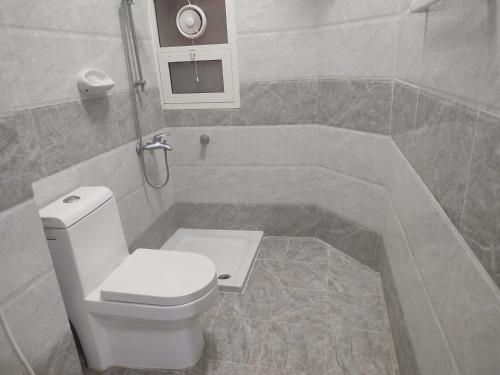 uma casa de banho com um WC branco e um lavatório. em رحاب السعاده rehab alsaadah apartment em Salalah