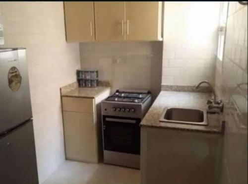 a small kitchen with a stove and a sink at رحاب السعاده rehab alsaadah apartment in Salalah