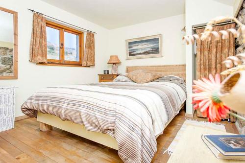 a bedroom with a large bed in a room at Cat's Cradle, Cottage In Beautiful and Peaceful Location, Near Beach in Sennen