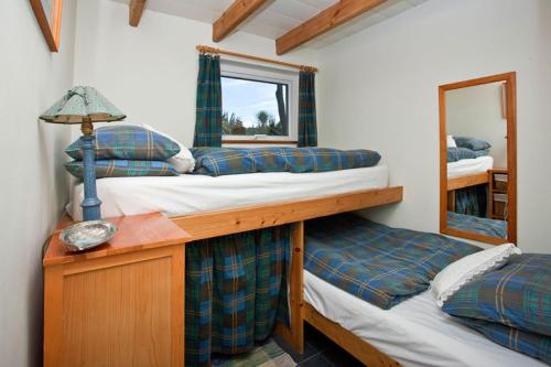 two bunk beds in a room with a mirror at Sheldrake, Spacious Villa, Panoramic Sea-views, Large Garden, By Beach in Sennen