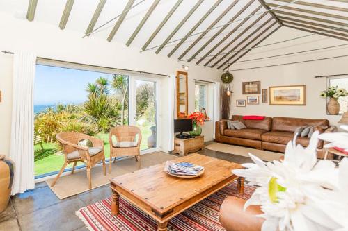 a living room with a view of the ocean at Sheldrake, Spacious Villa, Panoramic Sea-views, Large Garden, By Beach in Sennen