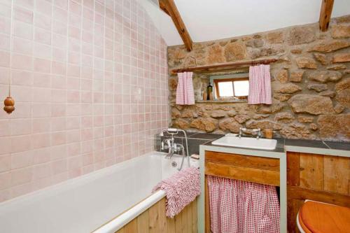 a bathroom with a bath tub and a sink at Petra, Cornish Cottage With lovely Garden, Wow Sea Views, By the Beach in Sennen