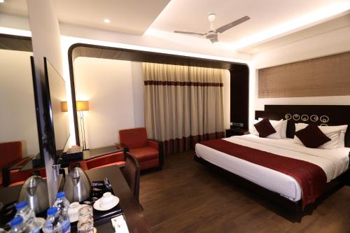 a hotel room with a bed and a chair at Hotel Godwin Deluxe - Free Airport Pick-Up in New Delhi