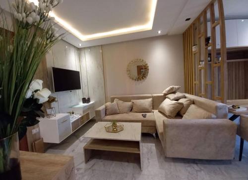 Modern apartment kantaoui sousse في Dar el Saïd: غرفة معيشة مع أريكة وطاولة