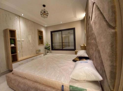 a bedroom with a large bed with a large mattressvisor at Modern apartment kantaoui sousse in Dar el Saïd