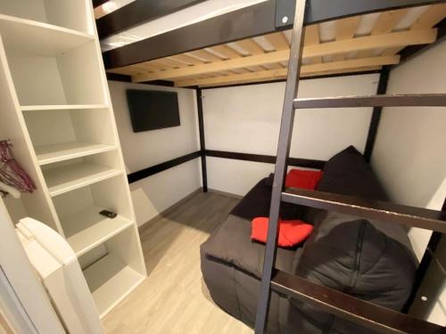 Cette petite chambre comprend des lits superposés et un canapé. dans l'établissement Appartement à la montagne au pied des pistes Classé 3 étoiles, à Saint-Lary-Soulan