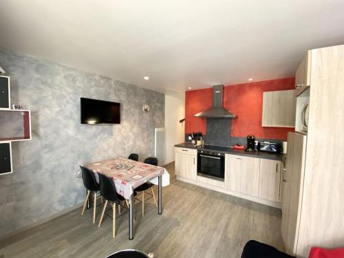 une cuisine avec une table et des chaises dans une pièce dans l'établissement Appartement à la montagne au pied des pistes Classé 3 étoiles, à Saint-Lary-Soulan