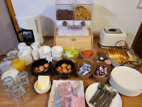 a table topped with bowls of eggs and other food at Batwo Stay - For foreigners only in Seoul