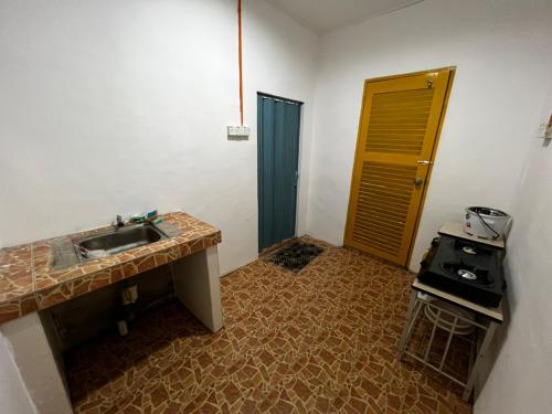 eine Küche mit Spüle und Herd im Zimmer in der Unterkunft TERATAK AL QARNI in Jitra