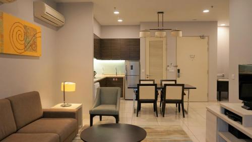a living room and kitchen with a table and chairs at Trinidad Suites Johor, Trademark Collection by Wyndham in Nusajaya