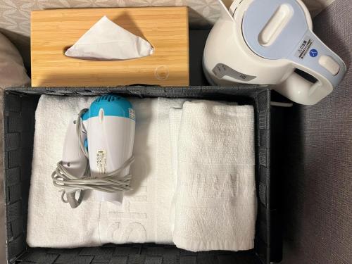a suitcase with a hair dryer and a towel at Miro Kyoto Nijo Hotel in Kyoto
