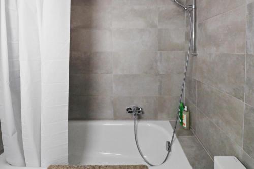 Appartement central et confortable في كرانس مونتانا: حمام مع دش مع حوض استحمام أبيض