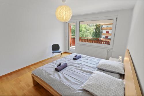 克莱恩 蒙塔纳Appartement central et confortable的一间卧室配有一张带椅子的床和一扇窗户