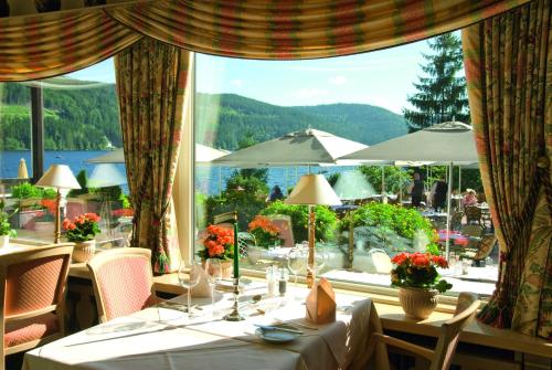 a dining room with tables and a large window at Treschers Schwarzwald Hotel in Titisee-Neustadt