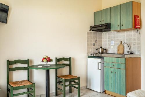 a kitchen with a table and two chairs and a sink at Anemona studio G in Katelios