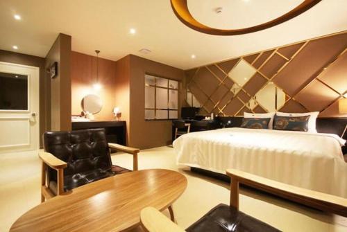 ein großes Schlafzimmer mit einem Bett und einem Tisch in der Unterkunft Hotel Able in Changwon