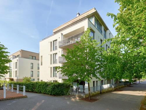 un gran edificio blanco con árboles delante de él en DünenResort Binz - Apt. 3.6, en Binz