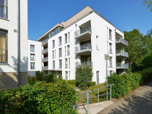 un edificio de apartamentos con arbustos delante de él en DünenResort Binz - Apt. 3.6, en Binz